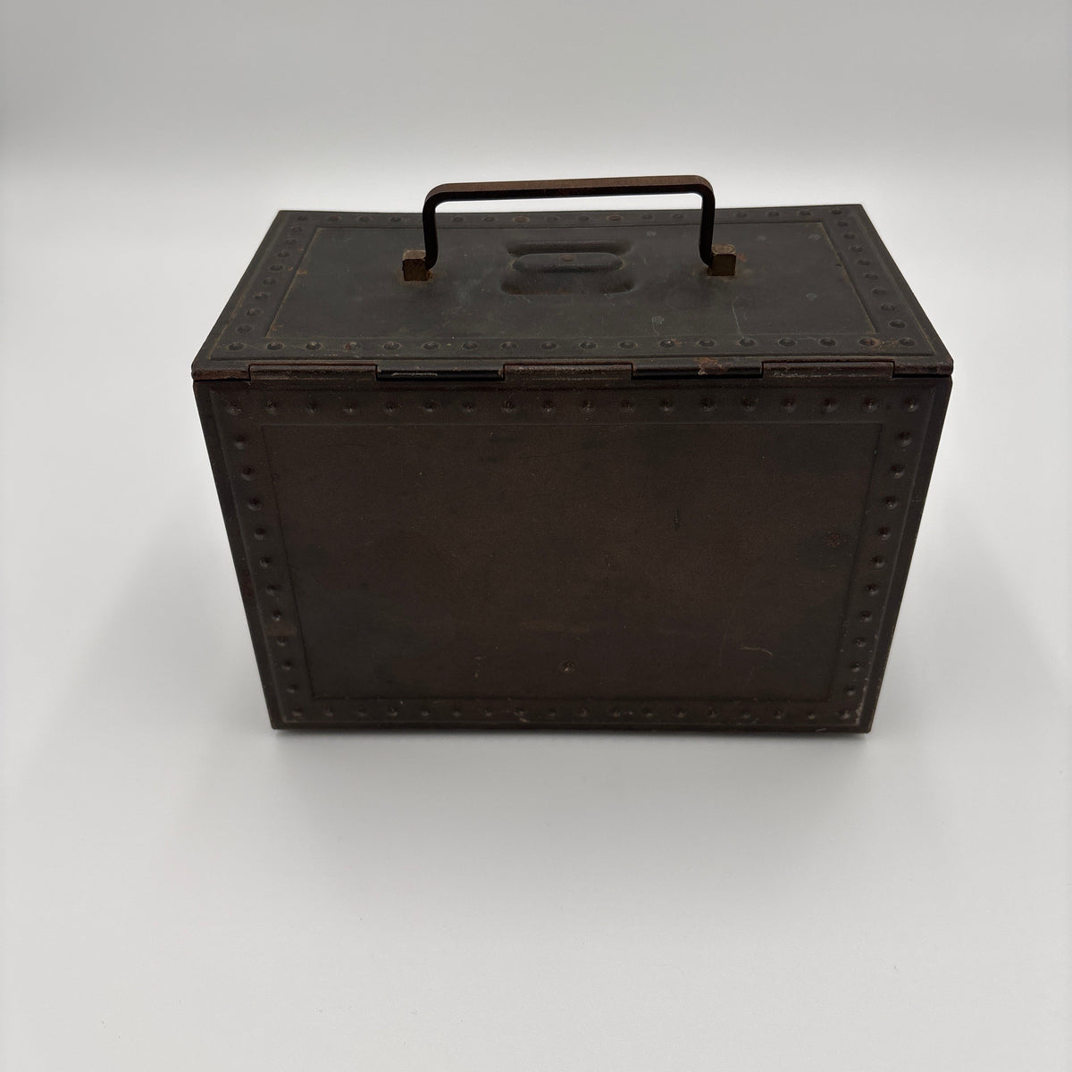 A dark brown leather storage box with a metal handle and decorative rivets, photographed on a neutral light gray background.