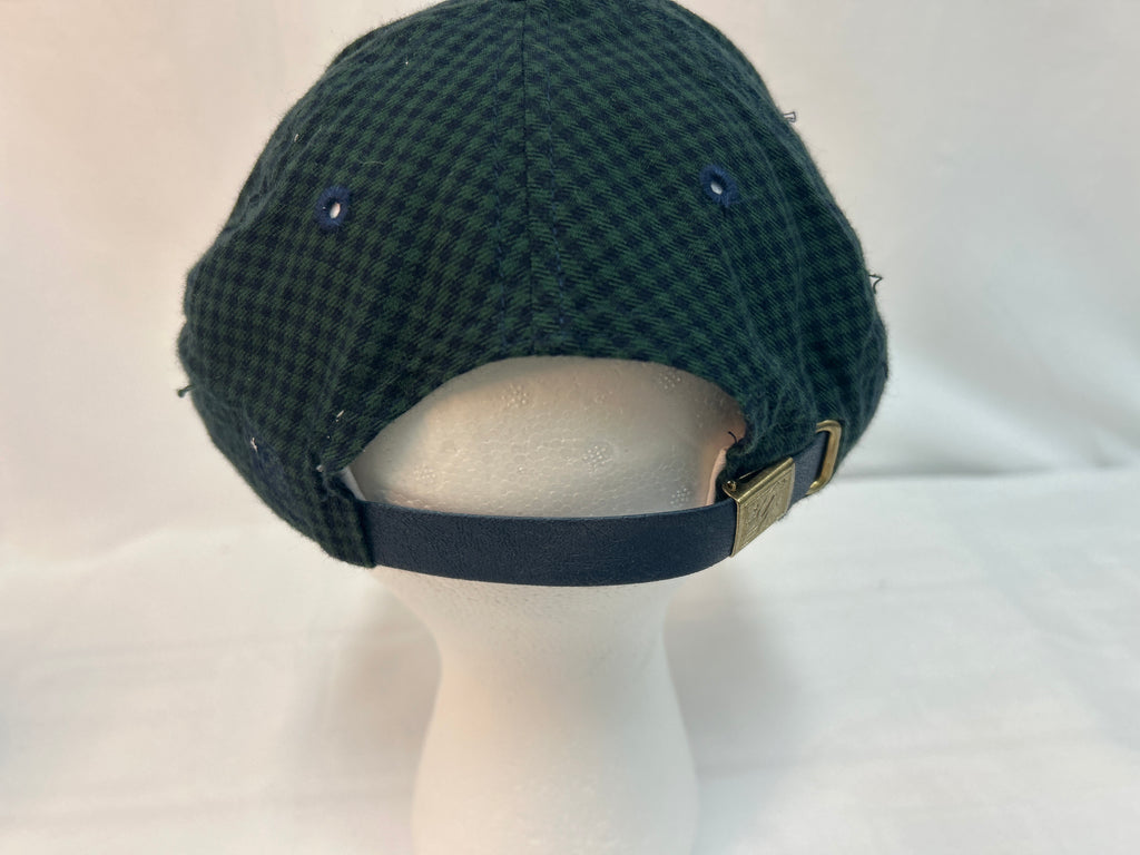 A dark green and black checkered flat cap displayed on a white mannequin head, showing the back strap and metal buckle.