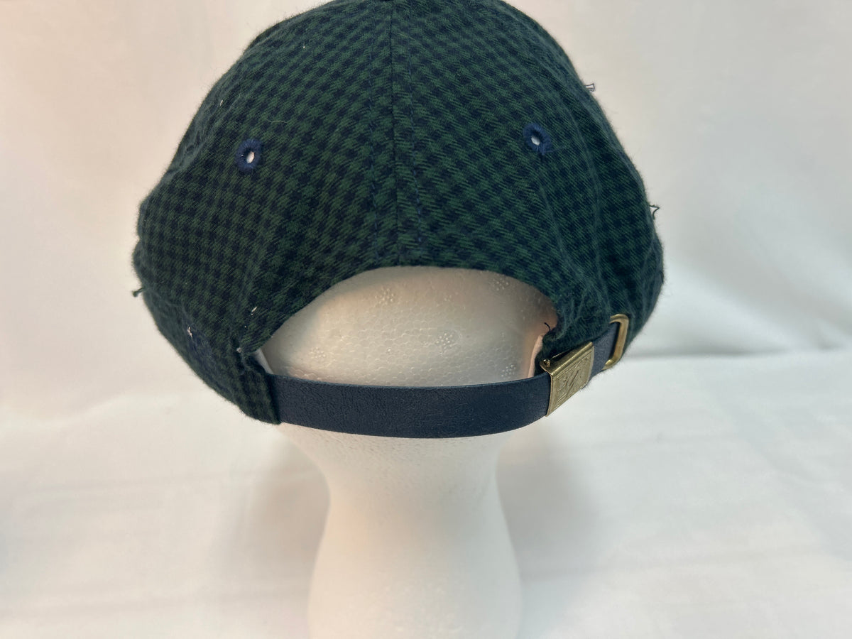 A dark green and black checkered flat cap displayed on a white mannequin head, showing the back strap and metal buckle.