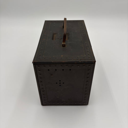 A vintage dark brown metal storage box with a hinged lid, a top handle, and decorative rivet detailing, shown on a light gray background.