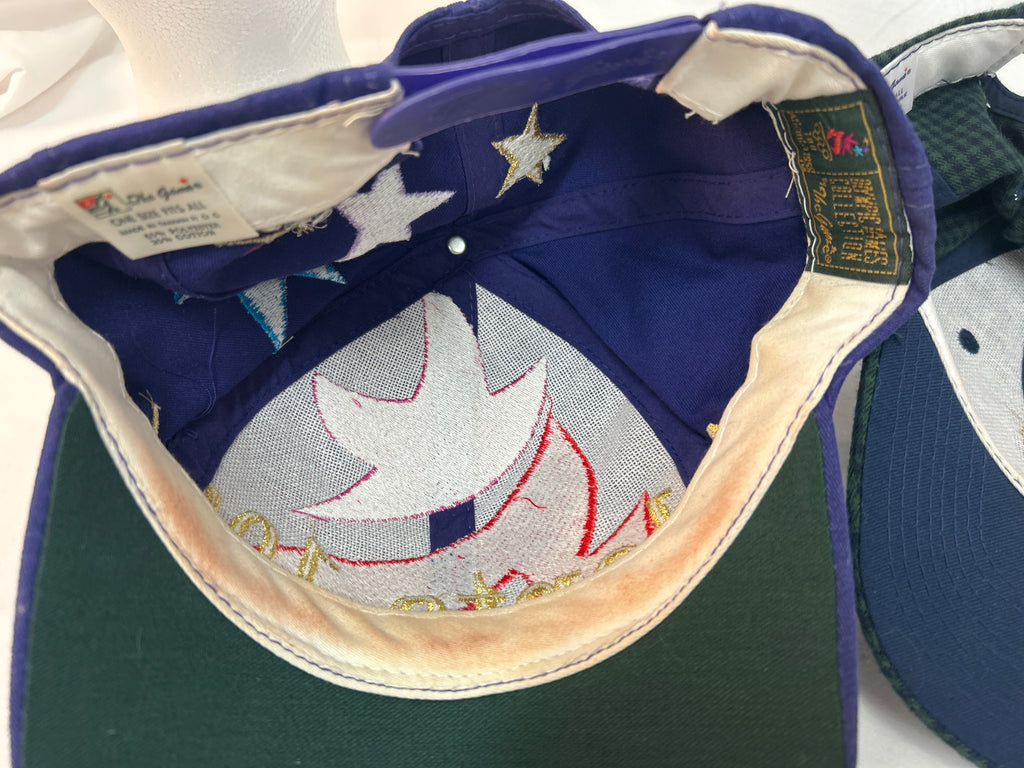 Close-up of the inside of a baseball cap showing a dark blue fabric crown with embroidered white stars and a white maple leaf design, a green brim, and interior labels.