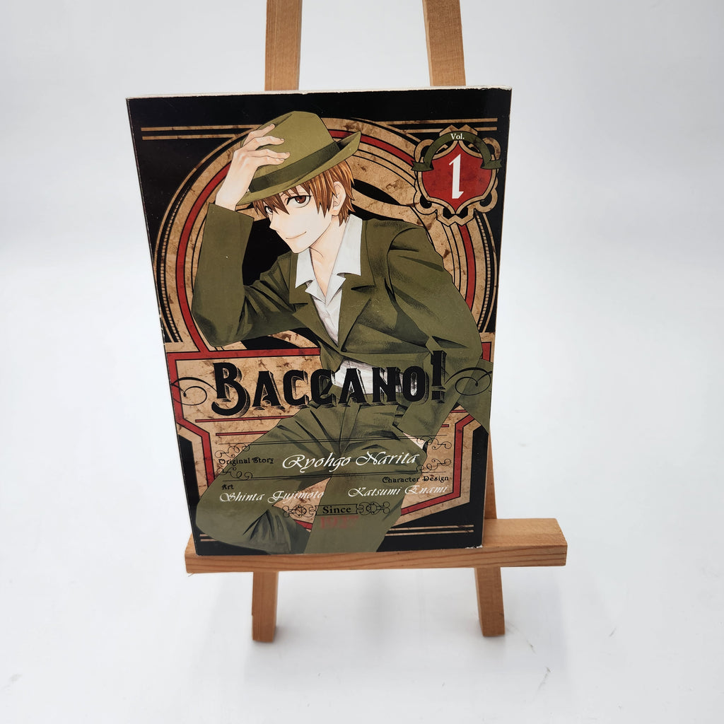 Baccano! Volume 1 manga book displayed on a small wooden easel against a white studio background.