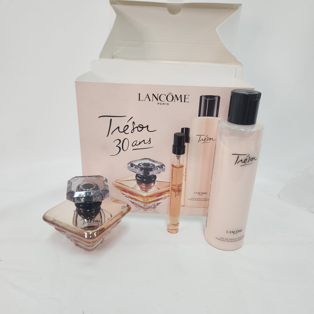 Lancôme Térbon Paris 30th anniversary gift set featuring a perfume bottle, a sample spray vial, a body mist bottle, and a lotion bottle arranged in front of their original pink packaging box.