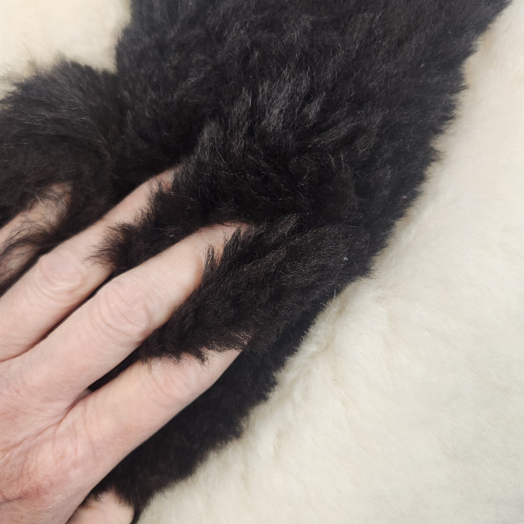 Vintage alpaca fur penguin pillow from Peru, front view of the black penguin motif on ivory plush fur soft and touchable