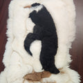 Vintage alpaca fur penguin pillow from Peru, front view of the black penguin motif on ivory plush fur