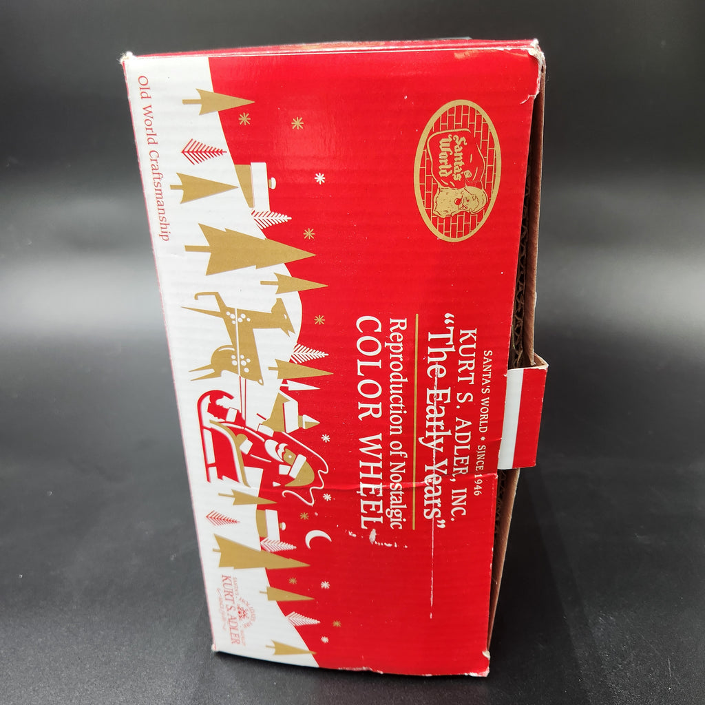 A red and white cardboard product box with gold holiday illustrations and text reading 'KIRT'S ADVENT INC. "The Early Years" Reproduction of Nostalgic Color Wheel'. Kurt Adler The Early Years Reproduction of the Nostalgic Color Wheel Light