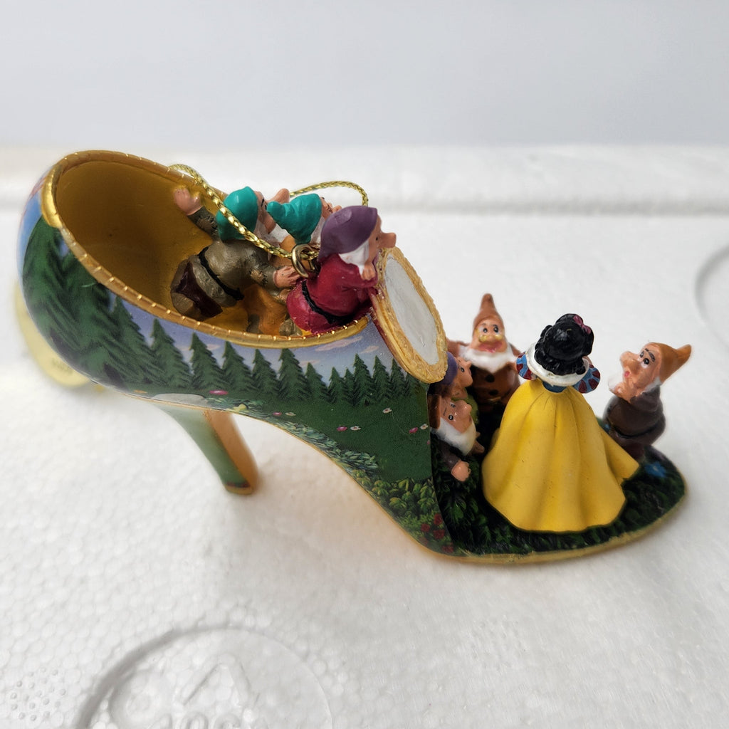 A miniature fairy tale shoe figurine with Snow White, the Seven Dwarves, and Cinderella, displayed on a white foam insert.