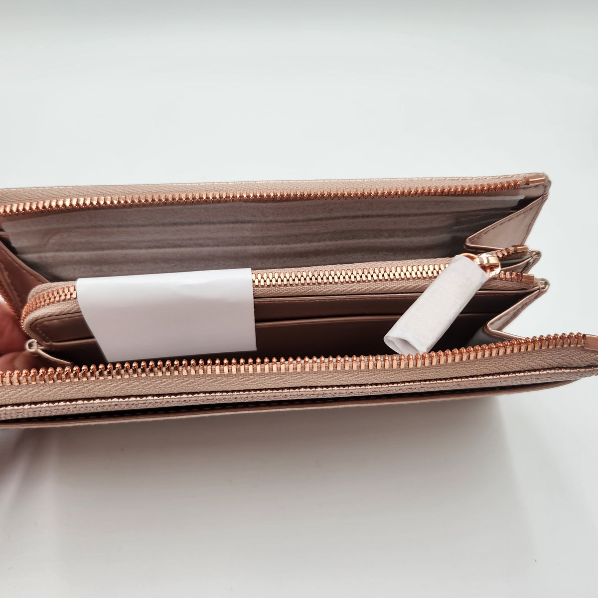 NWT Lacoste Chantaco Rose Gold Metallic Pique Leather Large Zip Around Wallet Clutch interior view showcasing compartments.