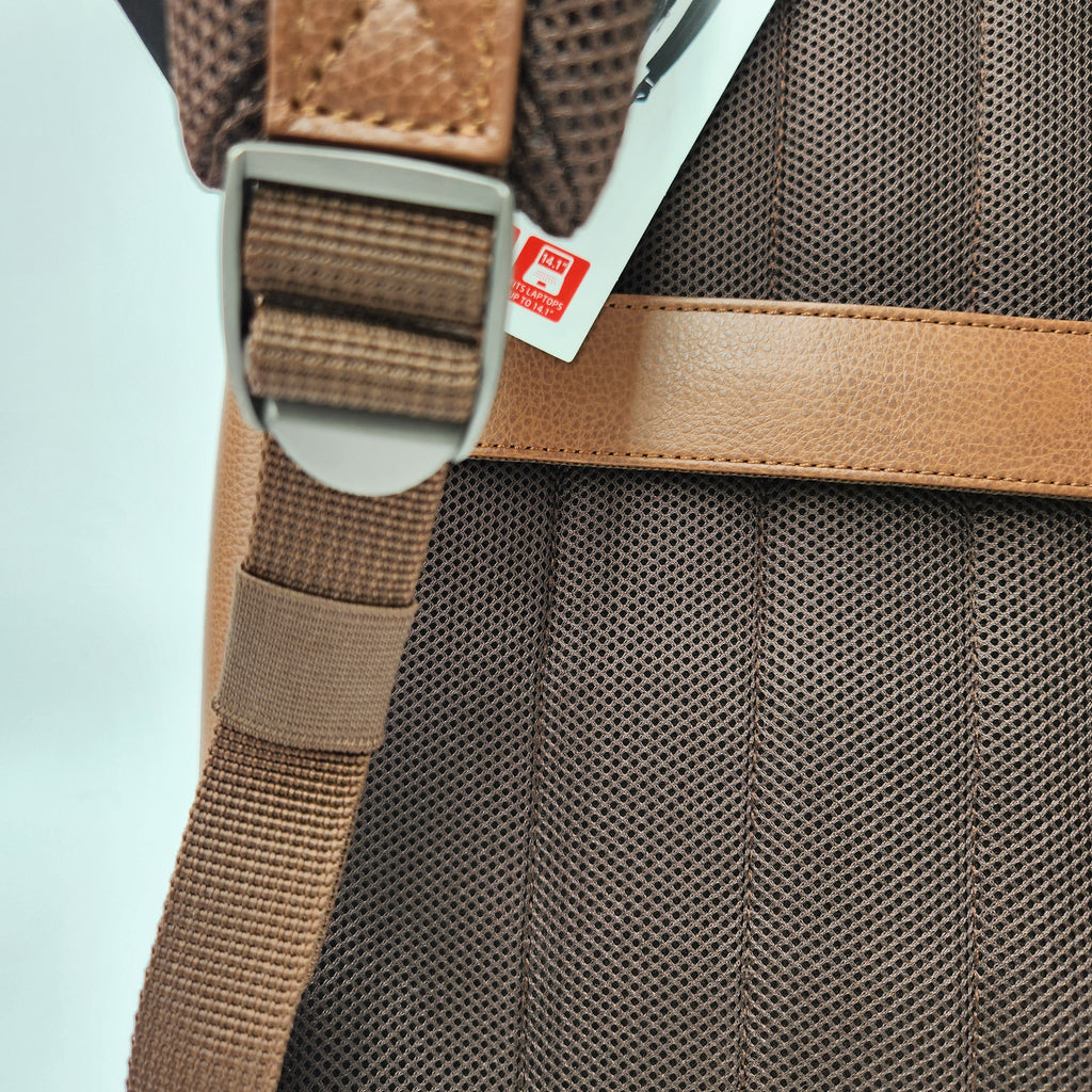 Close-up detail of a brown mesh  laptop backpack with tan leather trim, a metal buckle strap, and a hangtag showing the UNIQLO logo.