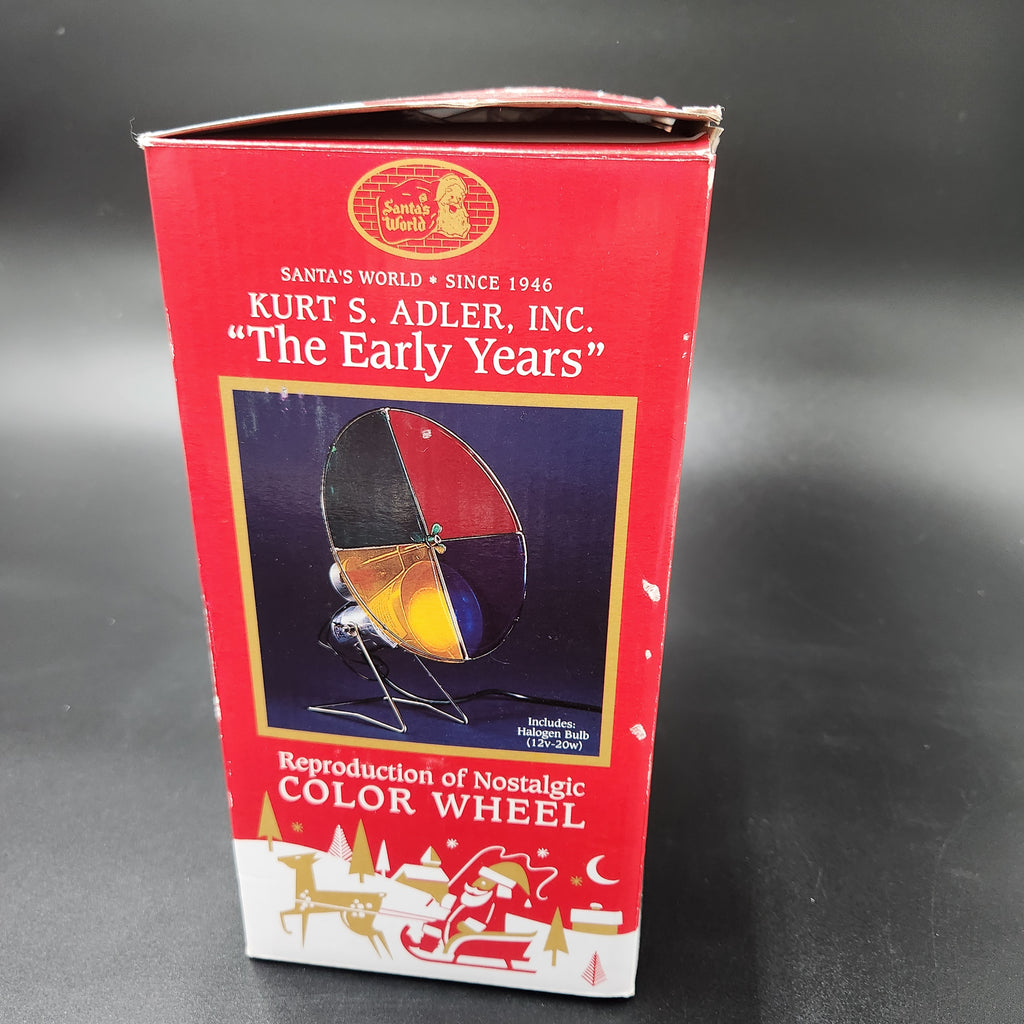 Vintage Santa's World 'The Early Years' color wheel toy box, showing the red packaging with a picture of the multi-colored spinning wheel and holiday illustrations at the bottom. Kurt Adler The Early Years Reproduction of the Nostalgic Color Wheel Light