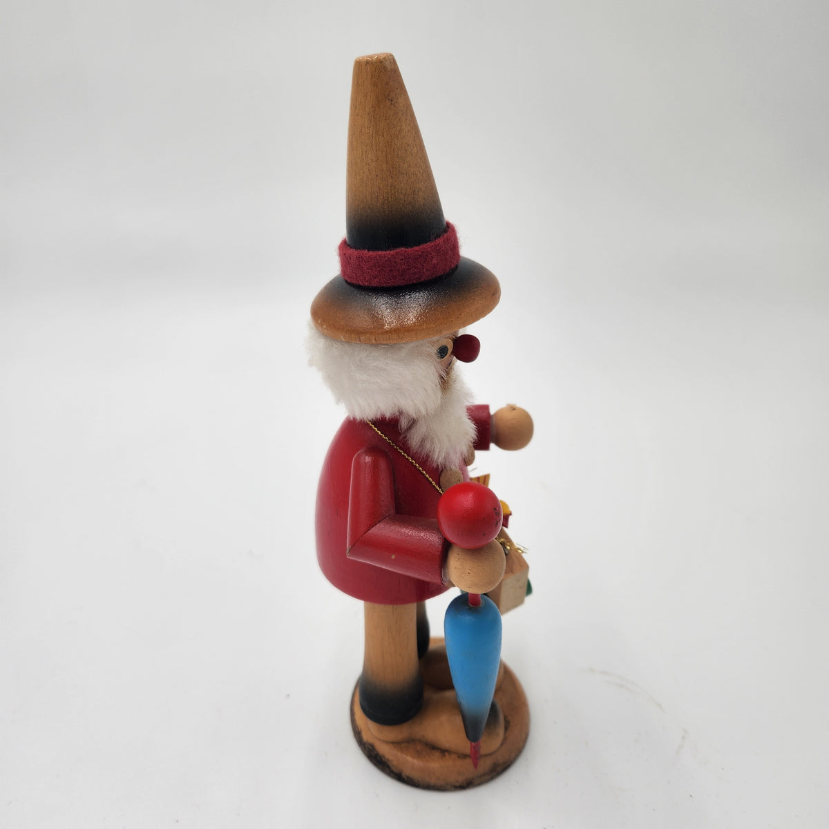 Vintage German Wood Smoker Erzgebirge Handcrafted wooden figurine in red attire holding colorful items.