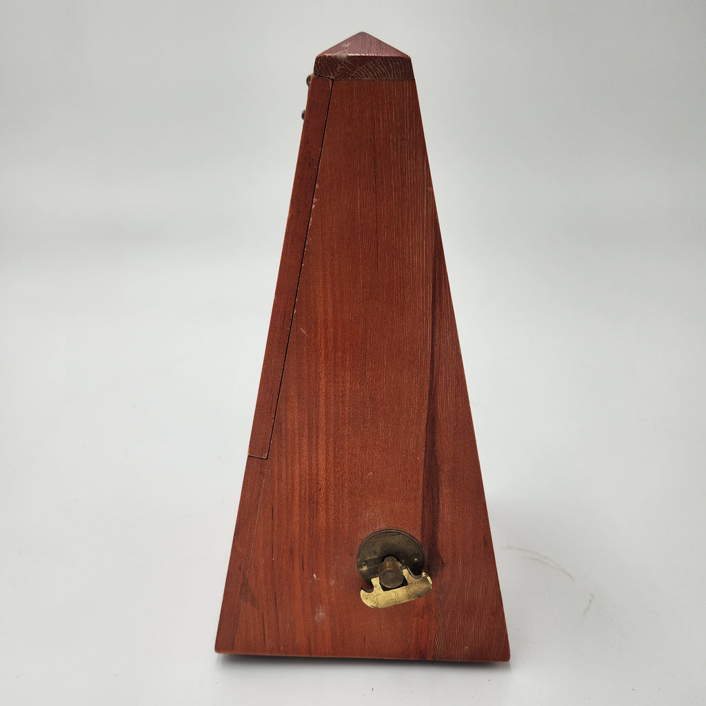 Seth Thomas wooden pyramid metronomes side view with a polished wood finish and brass latch for tuning.