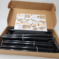 Open cardboard box containing black metal frame legs and a printed  Veehoo elevated dog bed assembly instruction sheet on a white background.