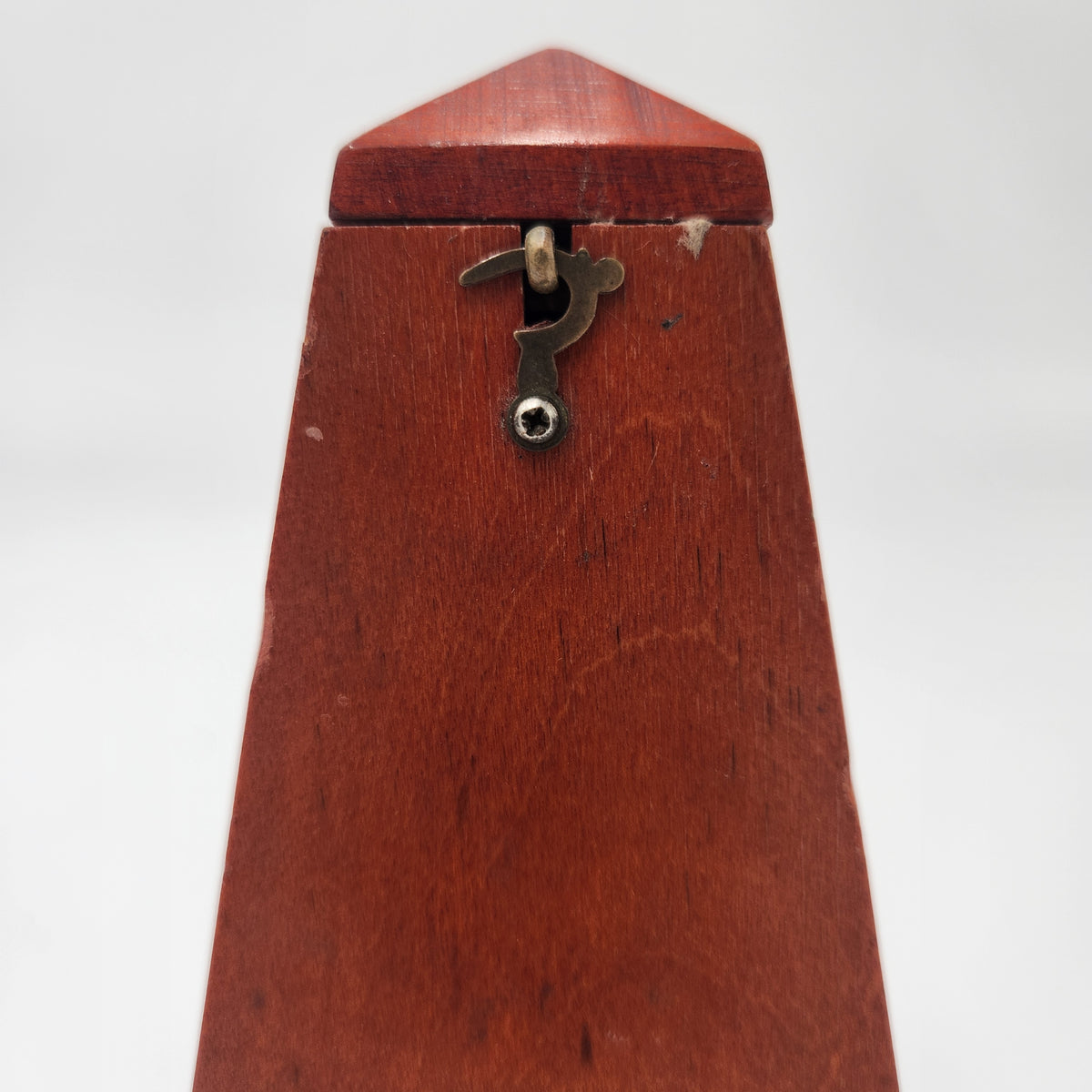 Seth Thomas wooden pyramid metronomes close-up of the top, highlighting the detailed craftsmanship and metal mechanism.