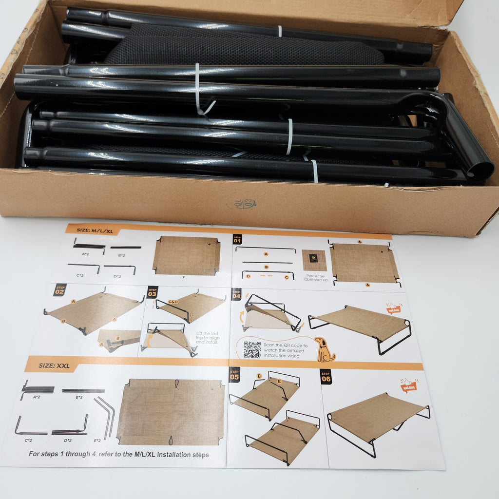 Black metal frames shown inside an open cardboard box, with an instruction sheet and size guide placed below on a white surface for Veehoo elevated dog bed.