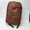 A brown textured leather Samsonite backpack with a horizontal zippered pocket, shown on a plain white background.