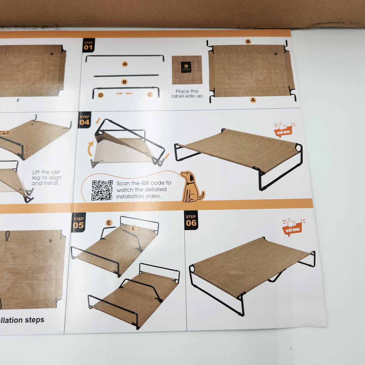 Instruction manual pages showing step-by-step assembly of a pet cot or elevated bed frame, with diagrams, numbered steps, and a QR code on a white background.