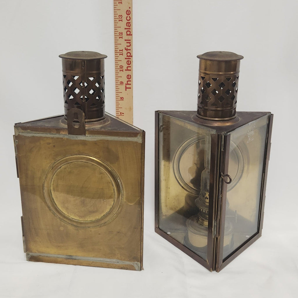 Two vintage brass lanterns with glass panels and perforated metal caps, shown side by side on a white background with a wooden ruler standing behind them for scale.