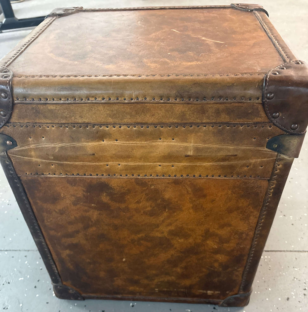 Vintage leather traveling trunk emblazoned with the British Royal Coat of Arms - top view of antique trunk.